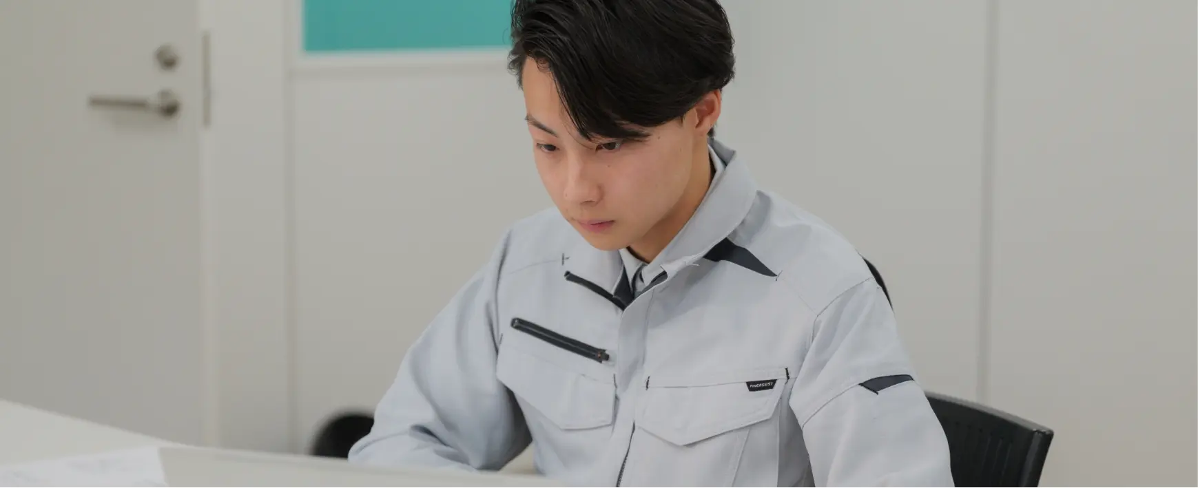 施工管理職がデスクで書類を作成している様子